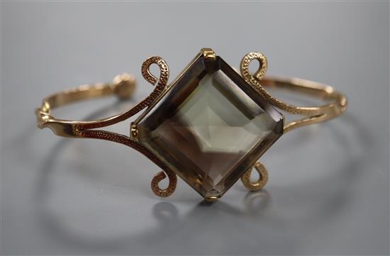 A yellow metal and smoky quartz set open bangle, gross weight 26.8 grams.